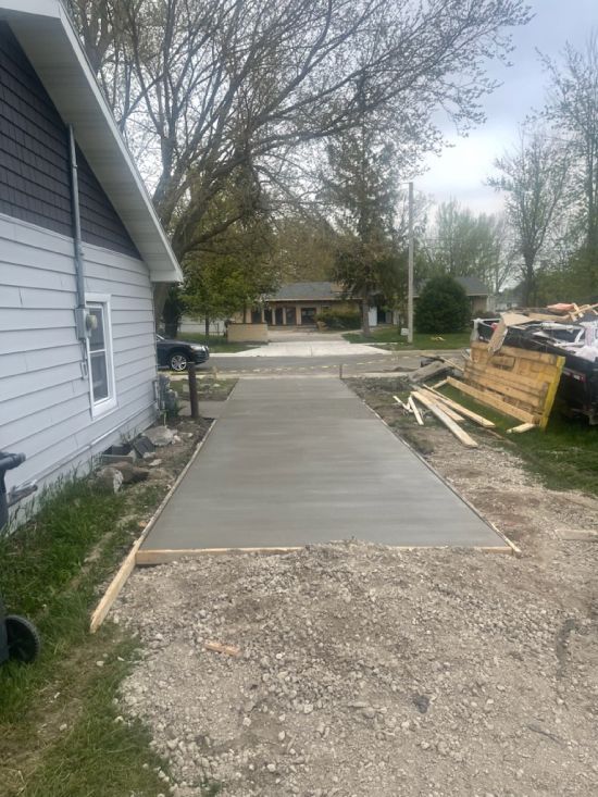 A concrete driveway is being built in front of a house.