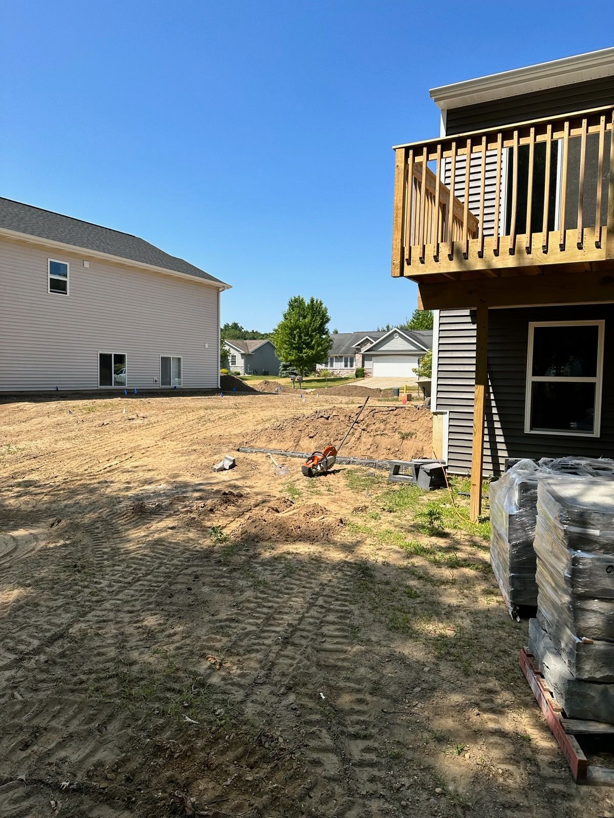 A house with a deck and a lot of dirt in front of it.