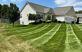 A large white house with a lush green lawn in front of it.