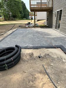 A concrete patio is being built in front of a house.