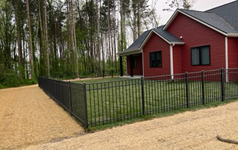 A red house with a black fence in front of it.