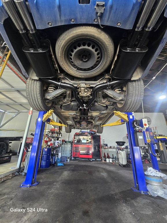 A Car Raised on a Lift in a Garage — Mechanic in Tamworth, NSW