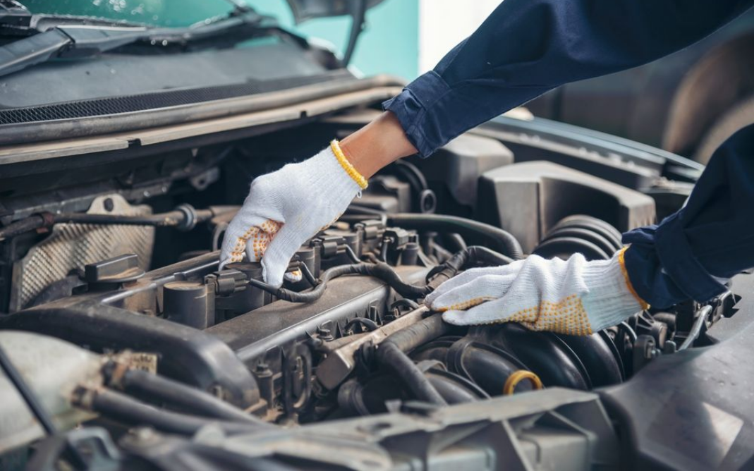 Mechanic Wearing Gloves Working on a Car Engine