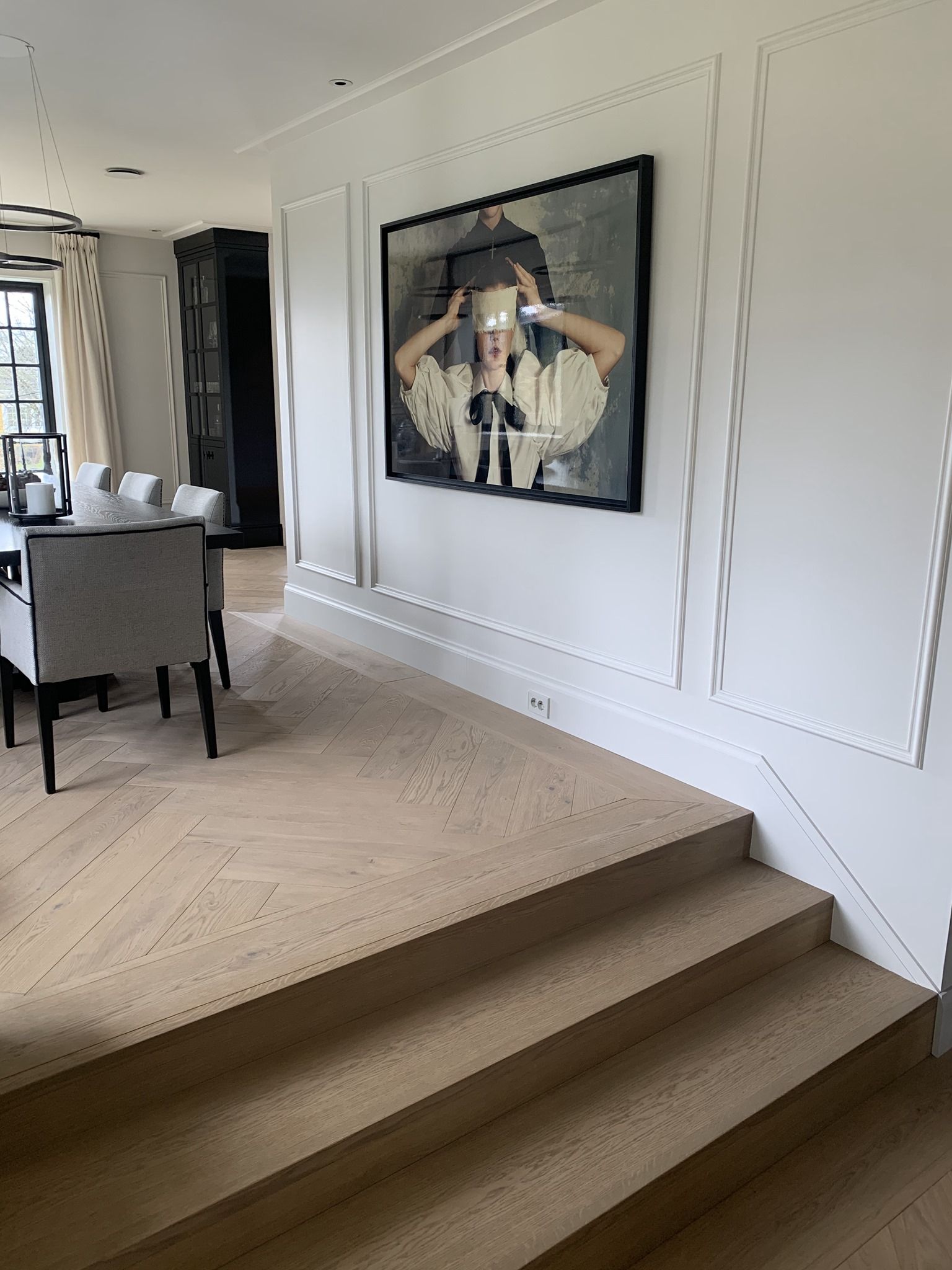 Det er et maleri på veggen over trappen i spisestuen.