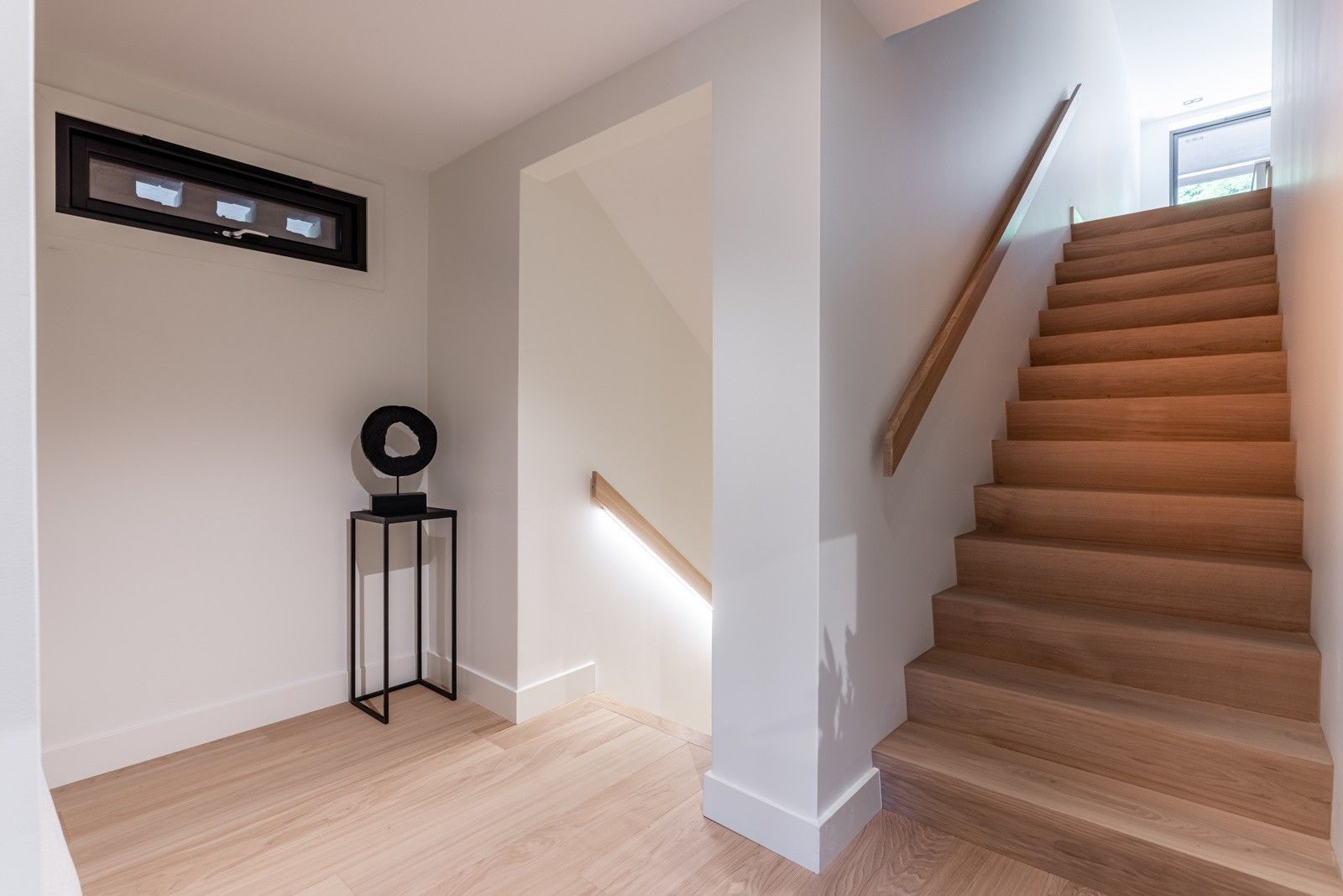 En gang med trapp som fører opp til andre etasje i et hus.