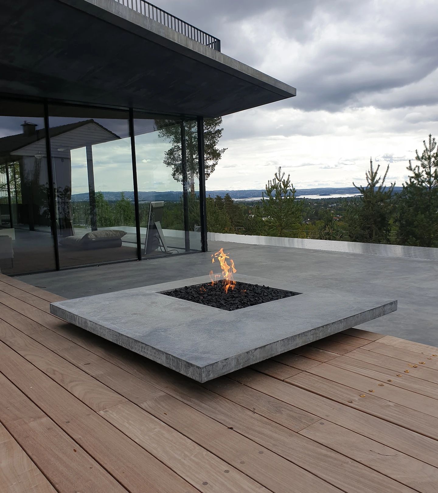 En branngrav sitter på et tredekke foran en bygning