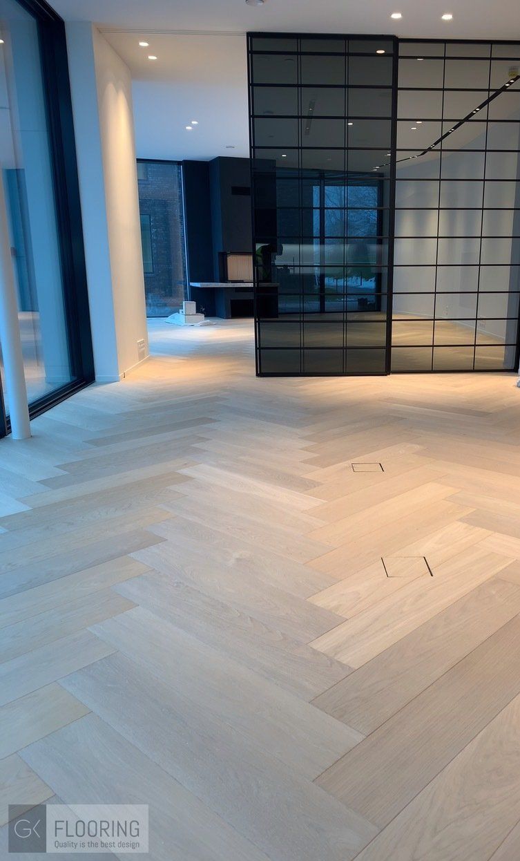 Et rom med fiskebeinsgulv og skyvedør i glass.