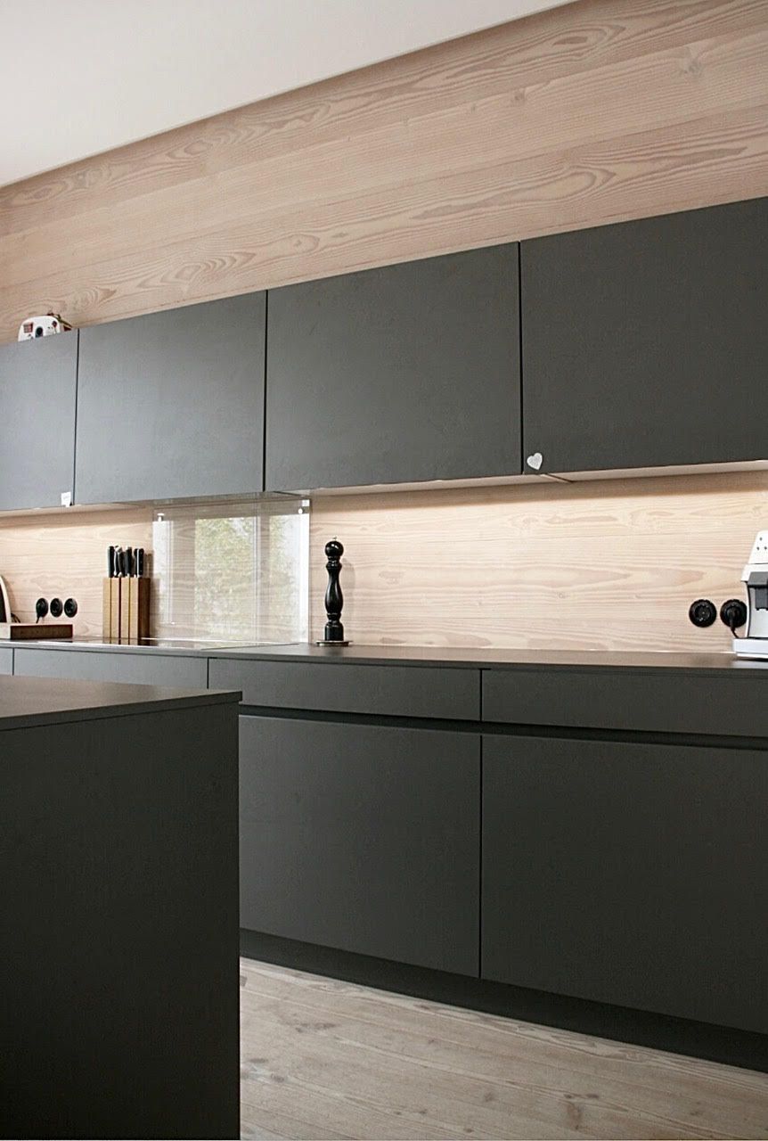 Et kjøkken med grå skap og trevegger