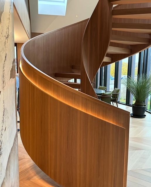 En spiraltrapp i tre med lys på rekkverket