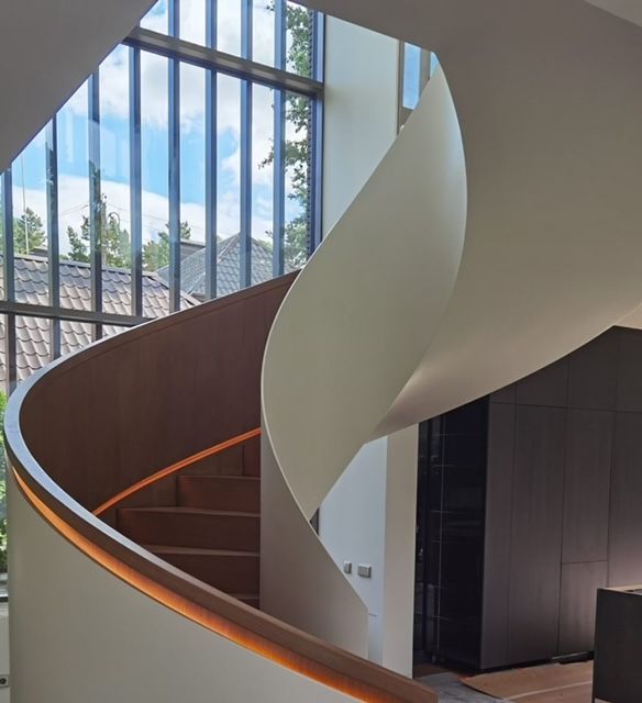 En spiraltrapp med et stort vindu bak