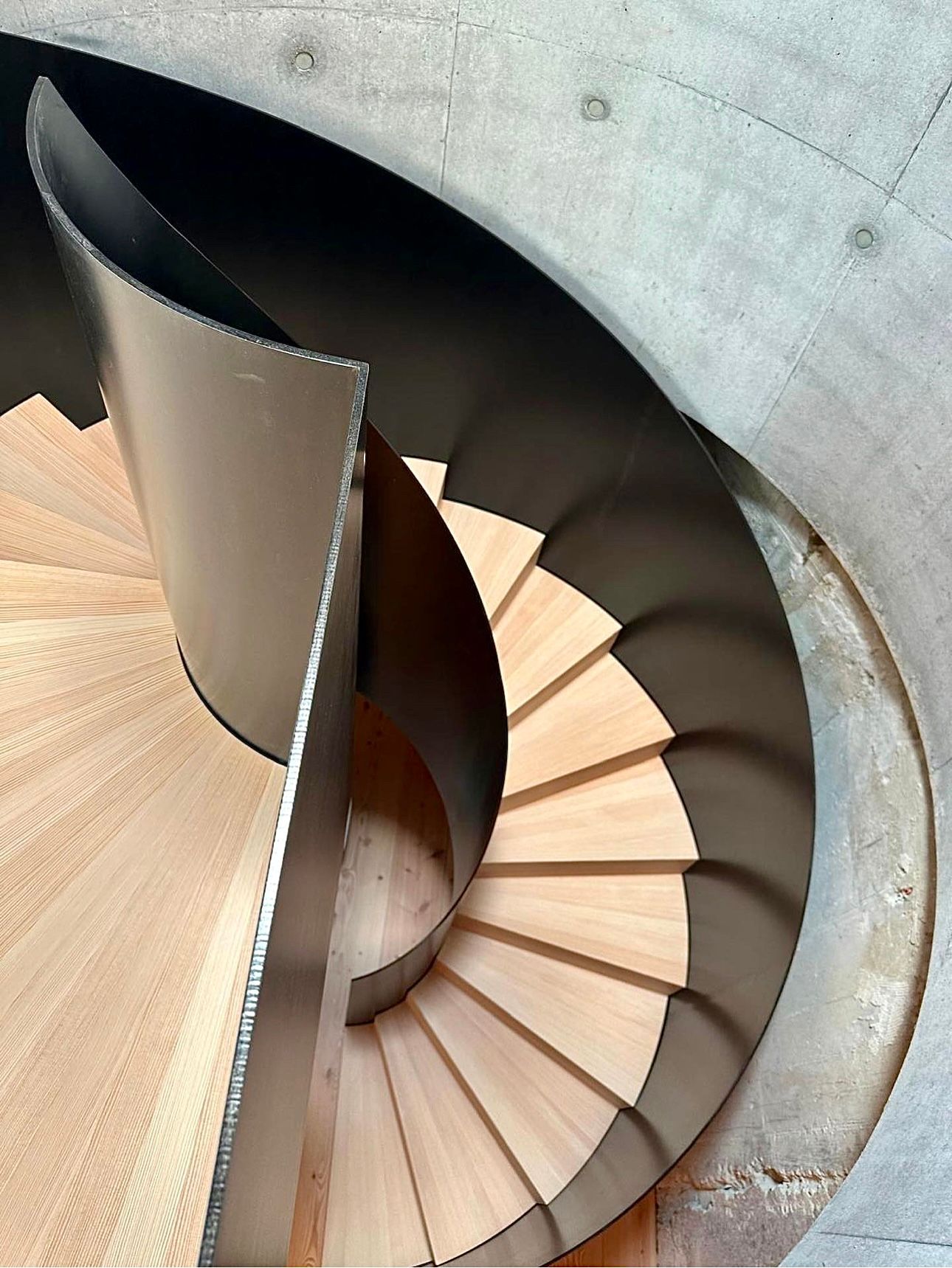 En spiraltrapp med tretrinn og et metallrekkverk