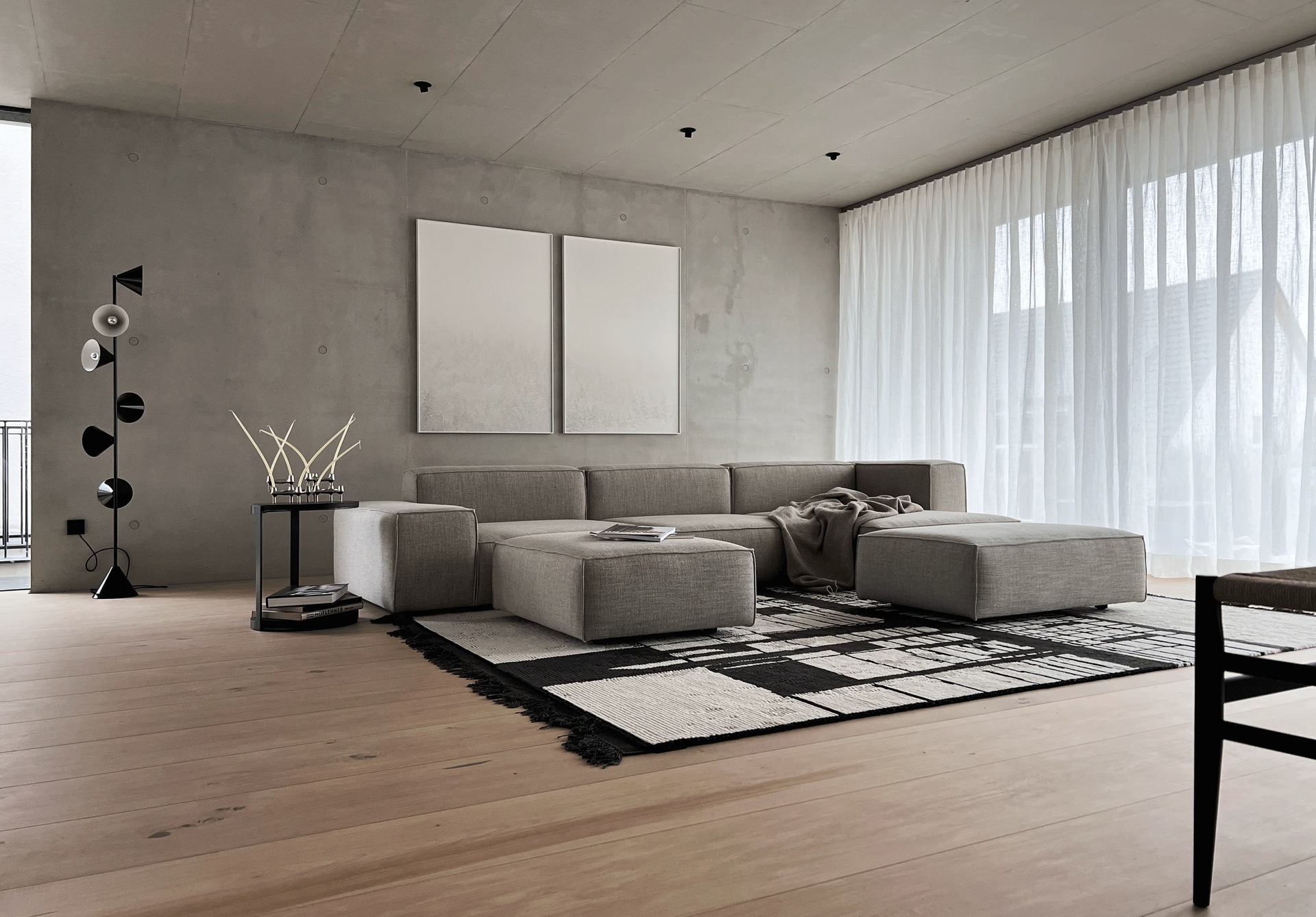 En stue med en sofa , ottoman , bord og stoler.