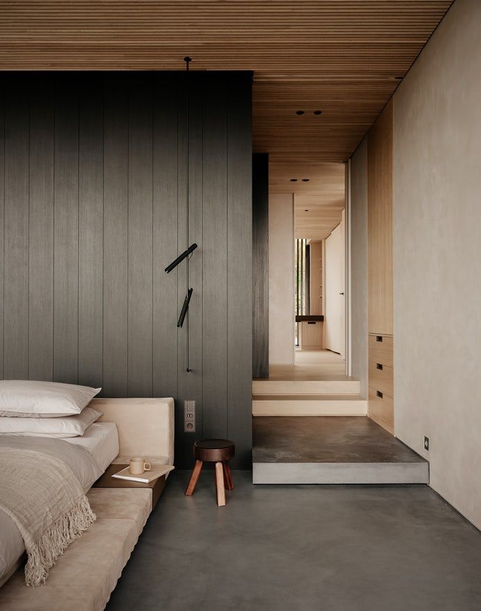 Et soverom med seng, krakk og trapp som fører til bad.