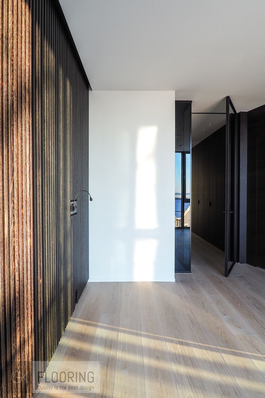 En gang med tregulv og hvit vegg