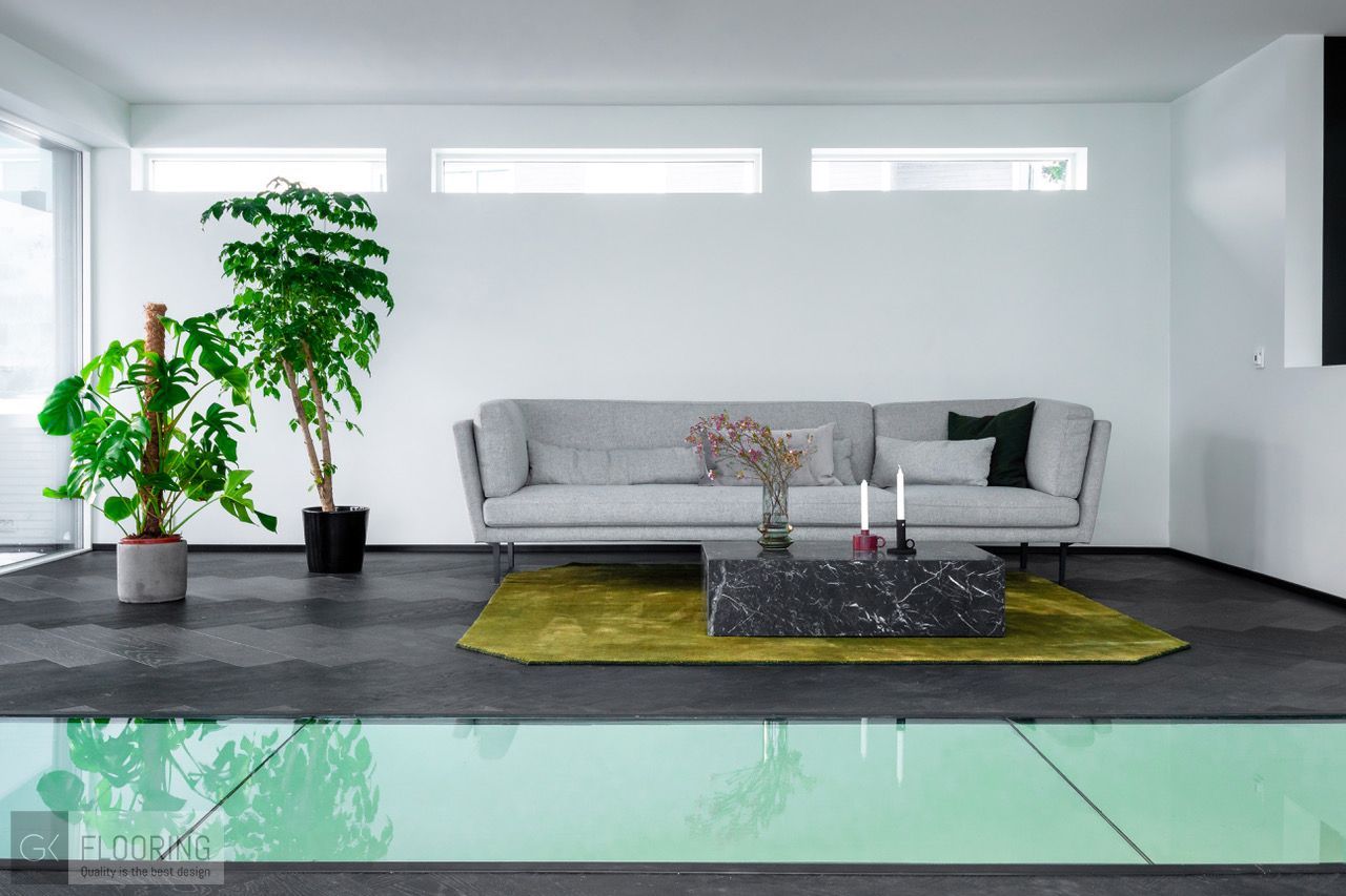 En stue med sofa , salongbord og potteplanter.