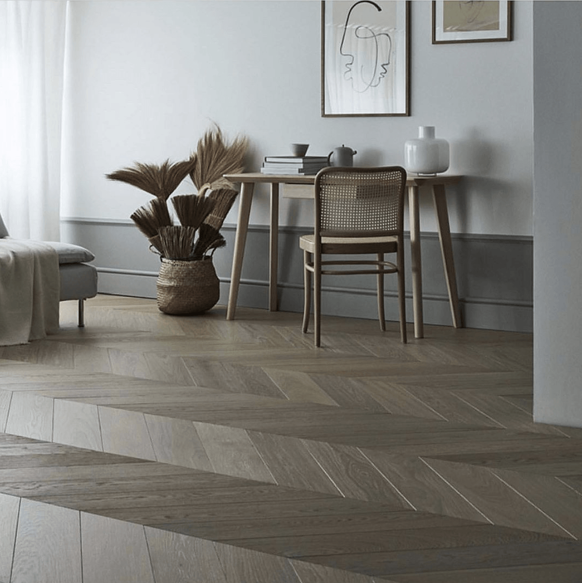 En stue med tregulv og kurvstol