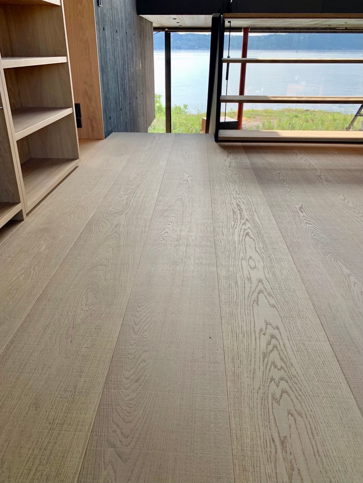 Et tregulv i en stue med utsikt over en innsjø.