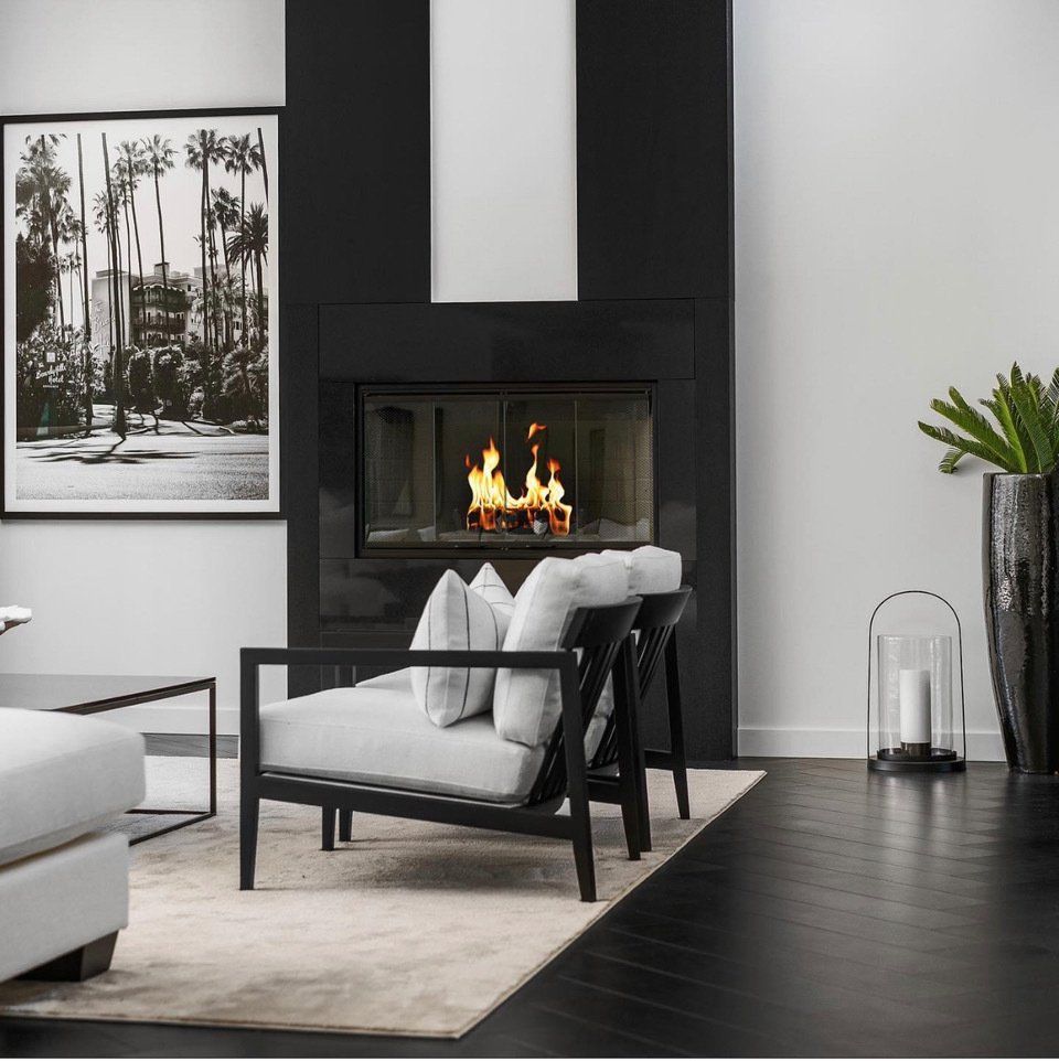 En stue med peis og et bilde av palmer på veggen