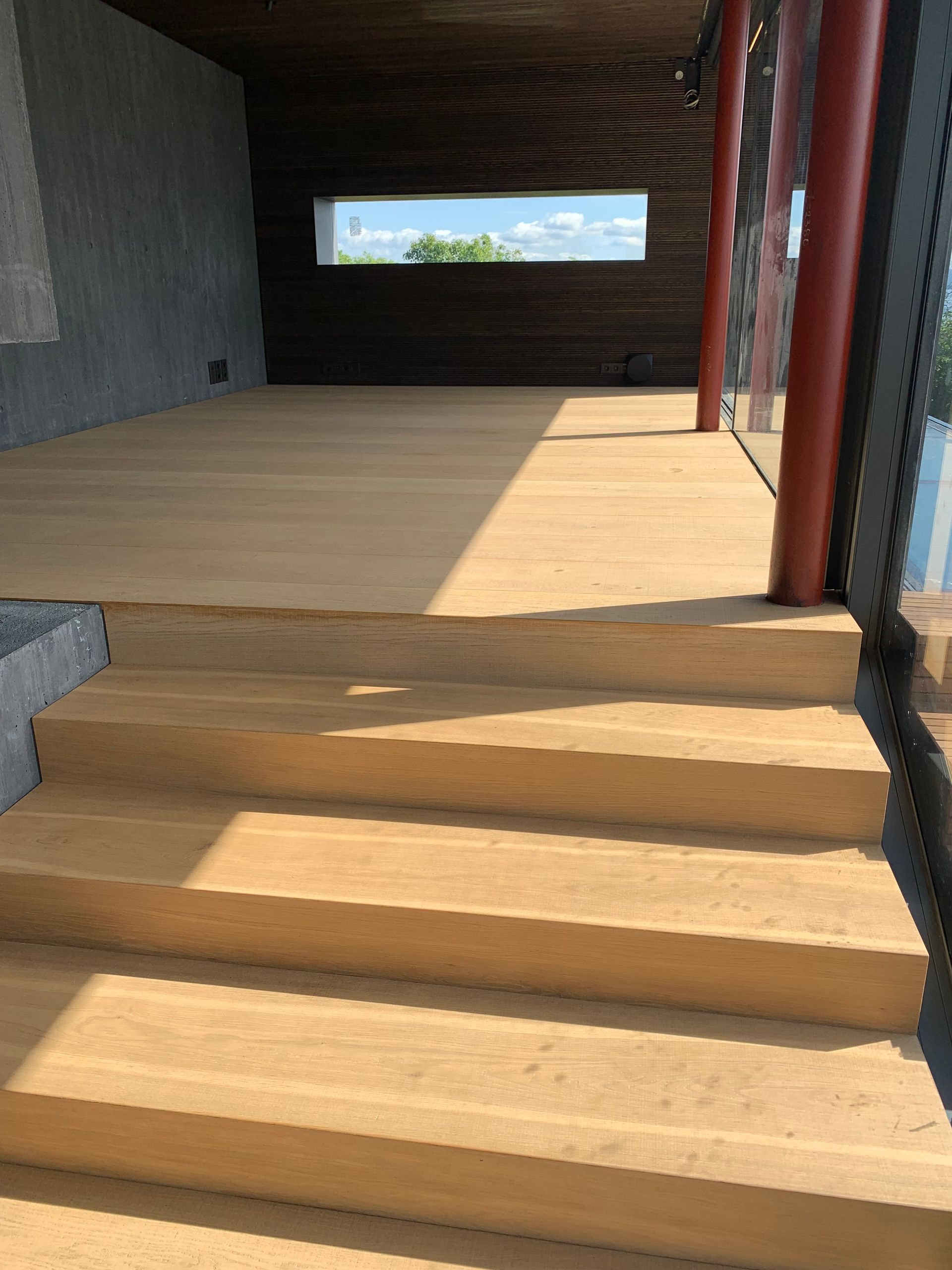 Et sett med trapper som fører opp til et treterrasse i en bygning.