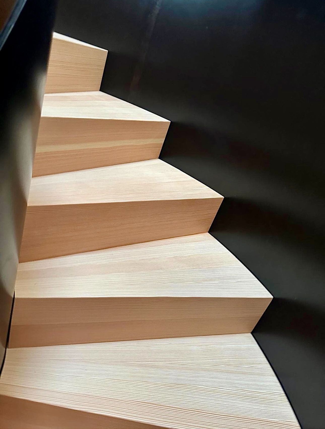 Et nærbilde av en tretrapp med svart rekkverk