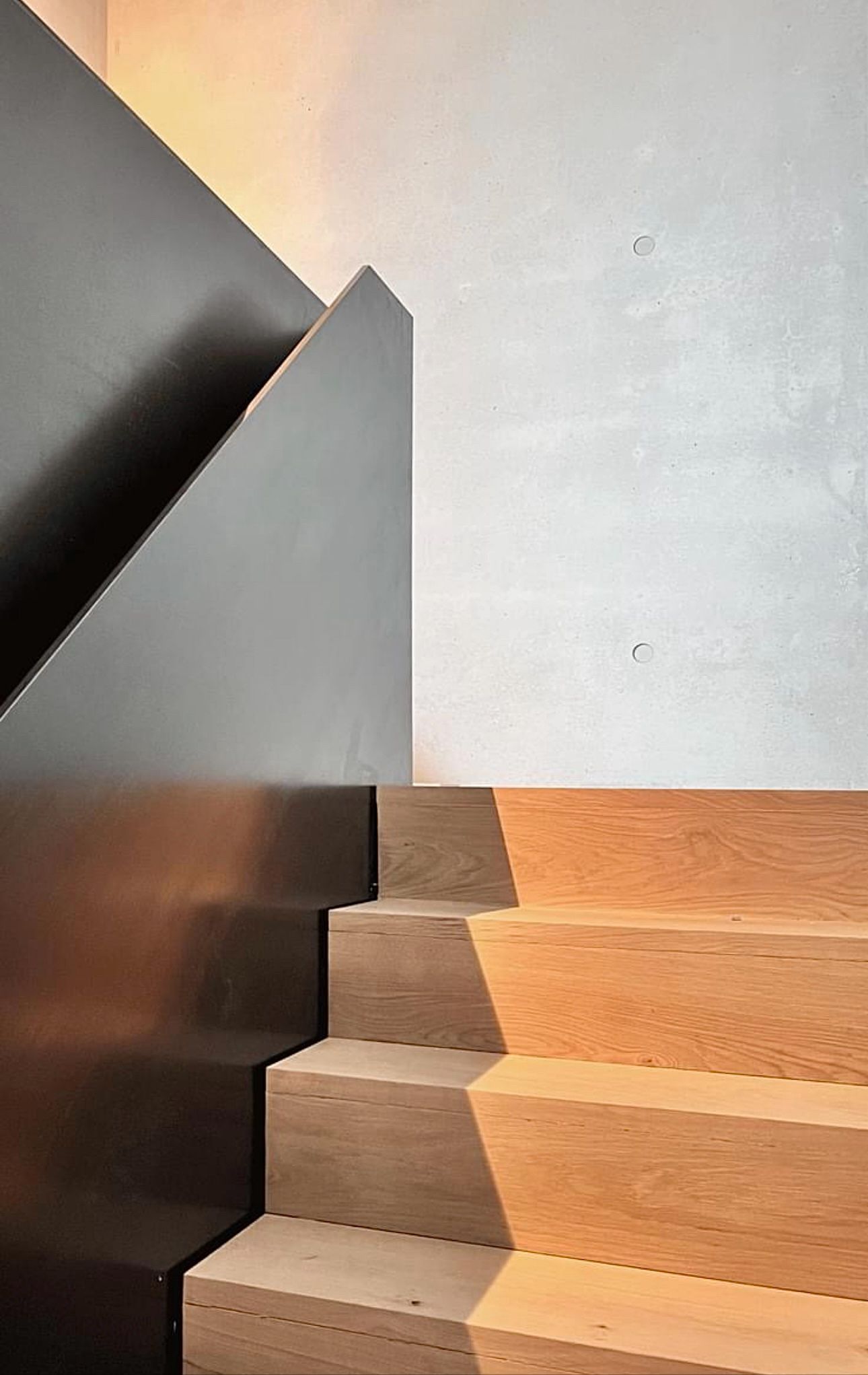 Et nærbilde av en tretrapp med svart rekkverk.