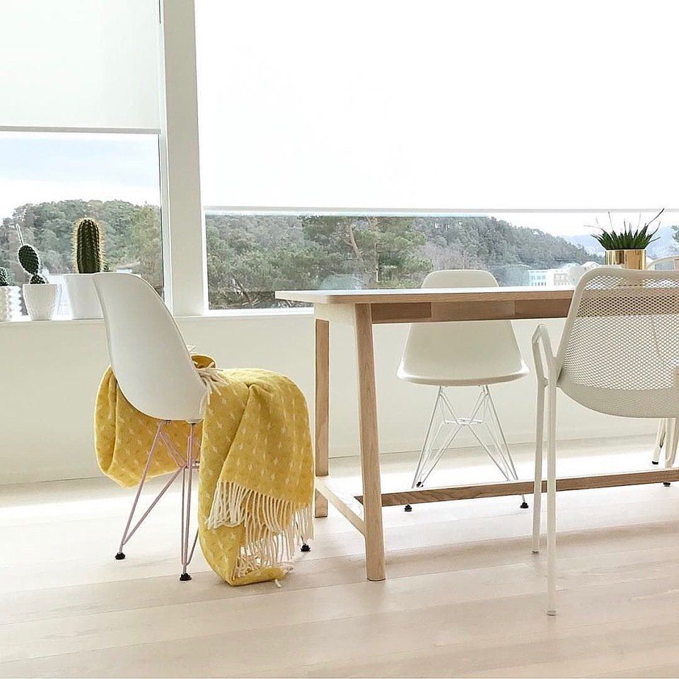 Et spisebord og stoler med et gult teppe på stolen