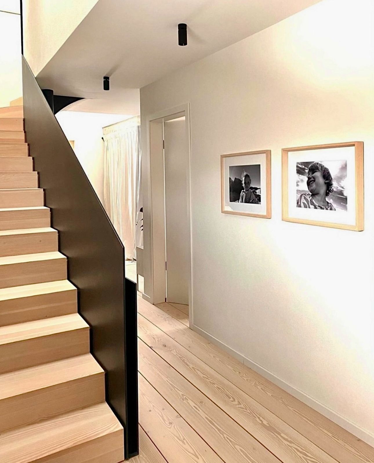 En gang med trapp og bilder på veggen