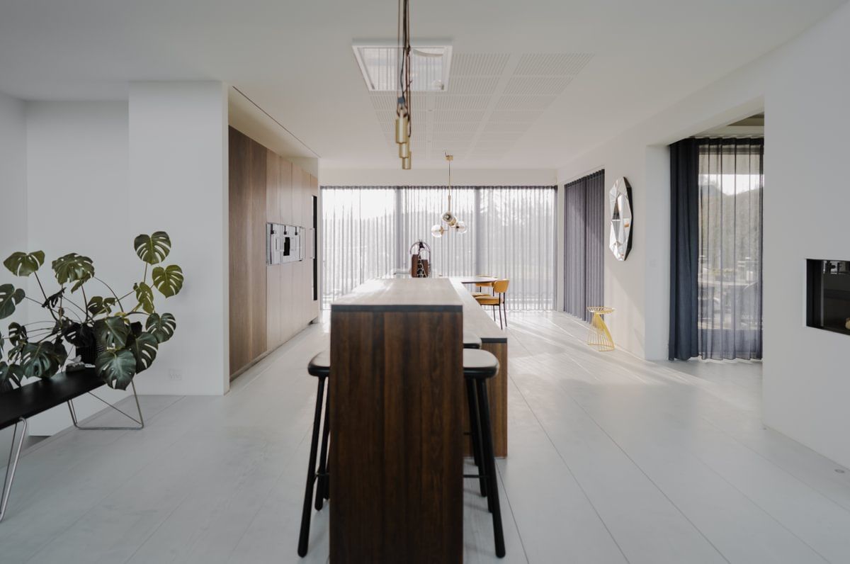 Et kjøkken med en lang treøy og krakker.