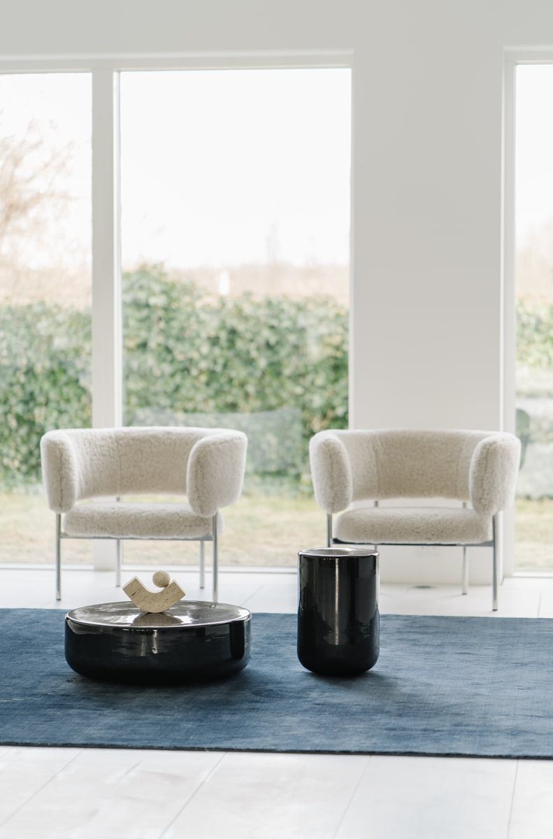 Det er to stoler og et salongbord i stuen.