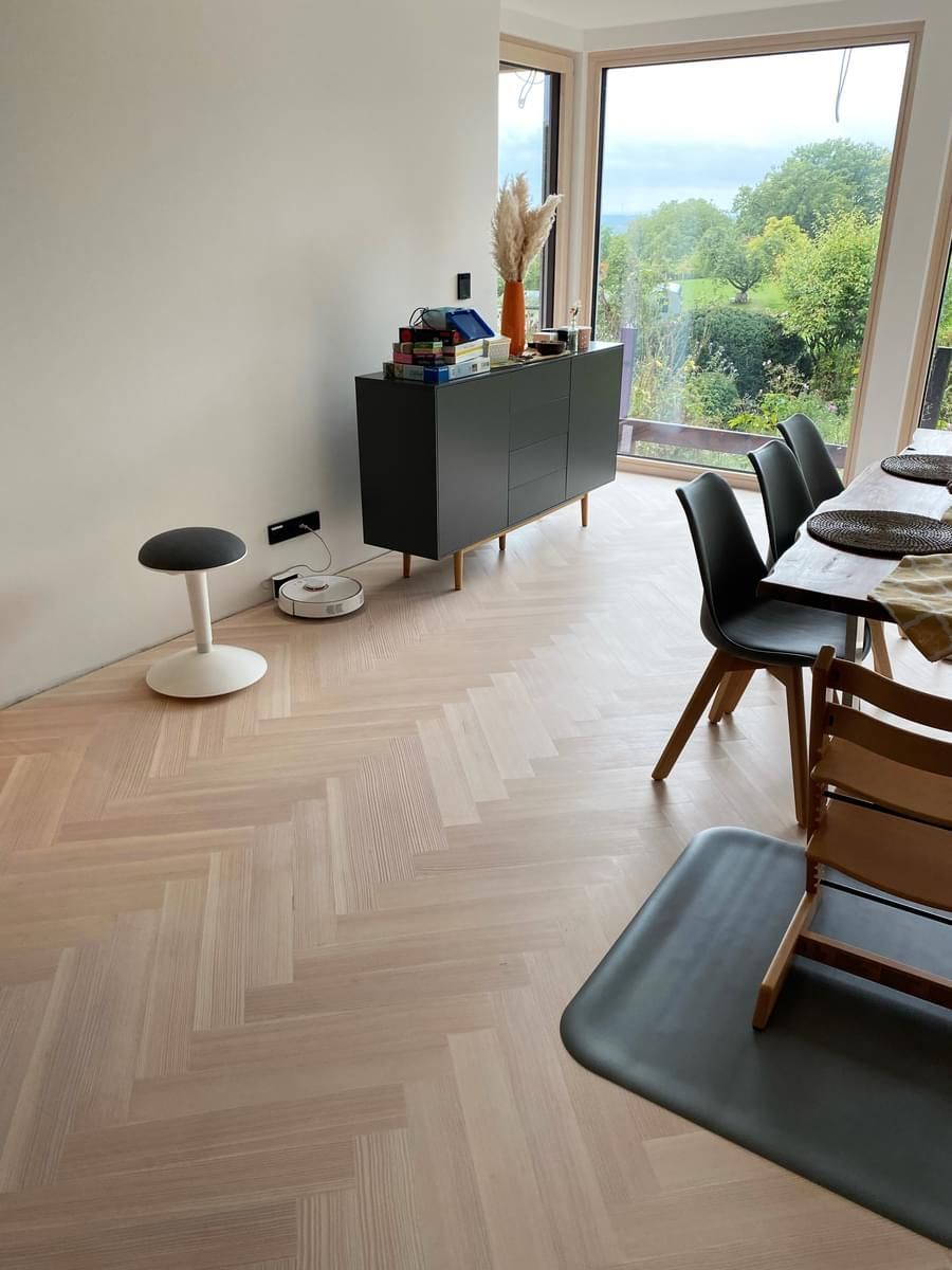 En stue med tregulv og bord og stoler