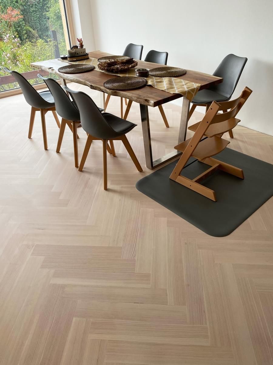 En spisestue med et trebord og stoler og en høy stol.