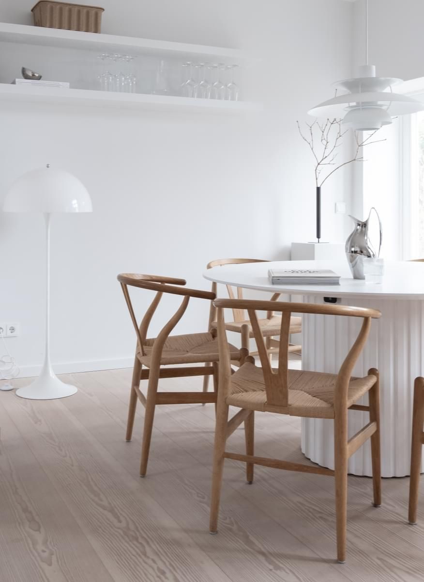 En spisestue med bord og stoler og en lampe