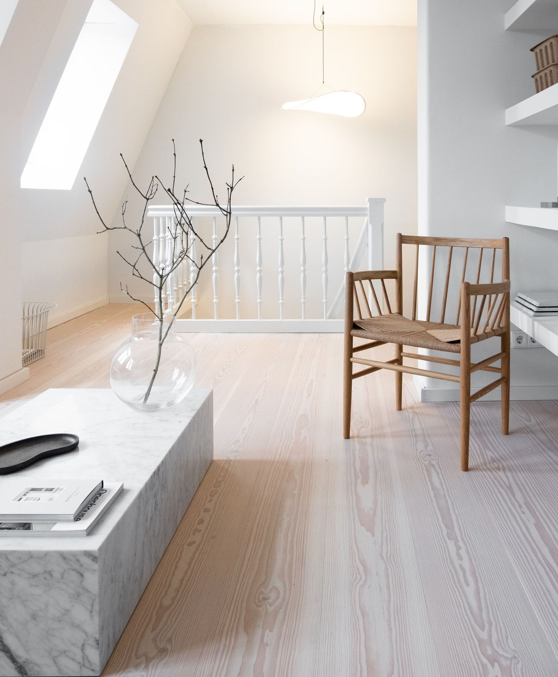 En stue med en stol og en vase med blomster