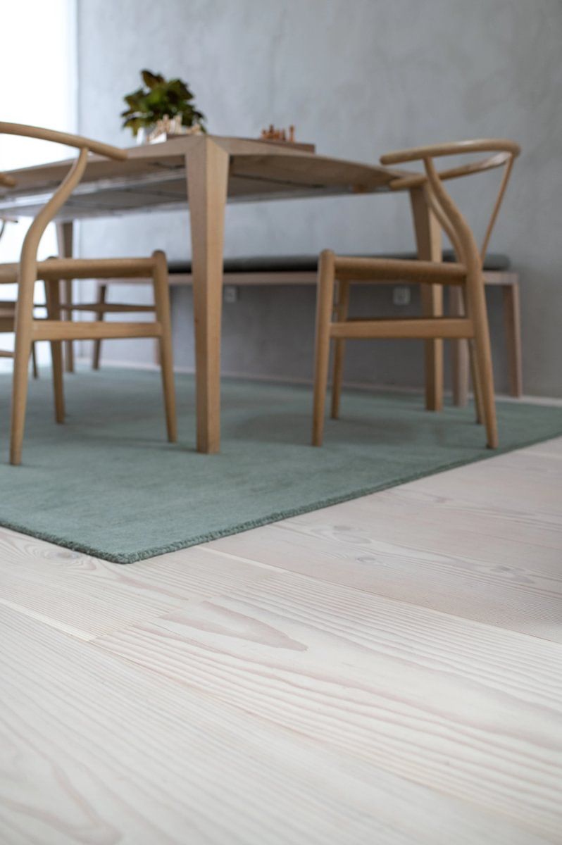 En spisestue med bord og stoler på et teppe