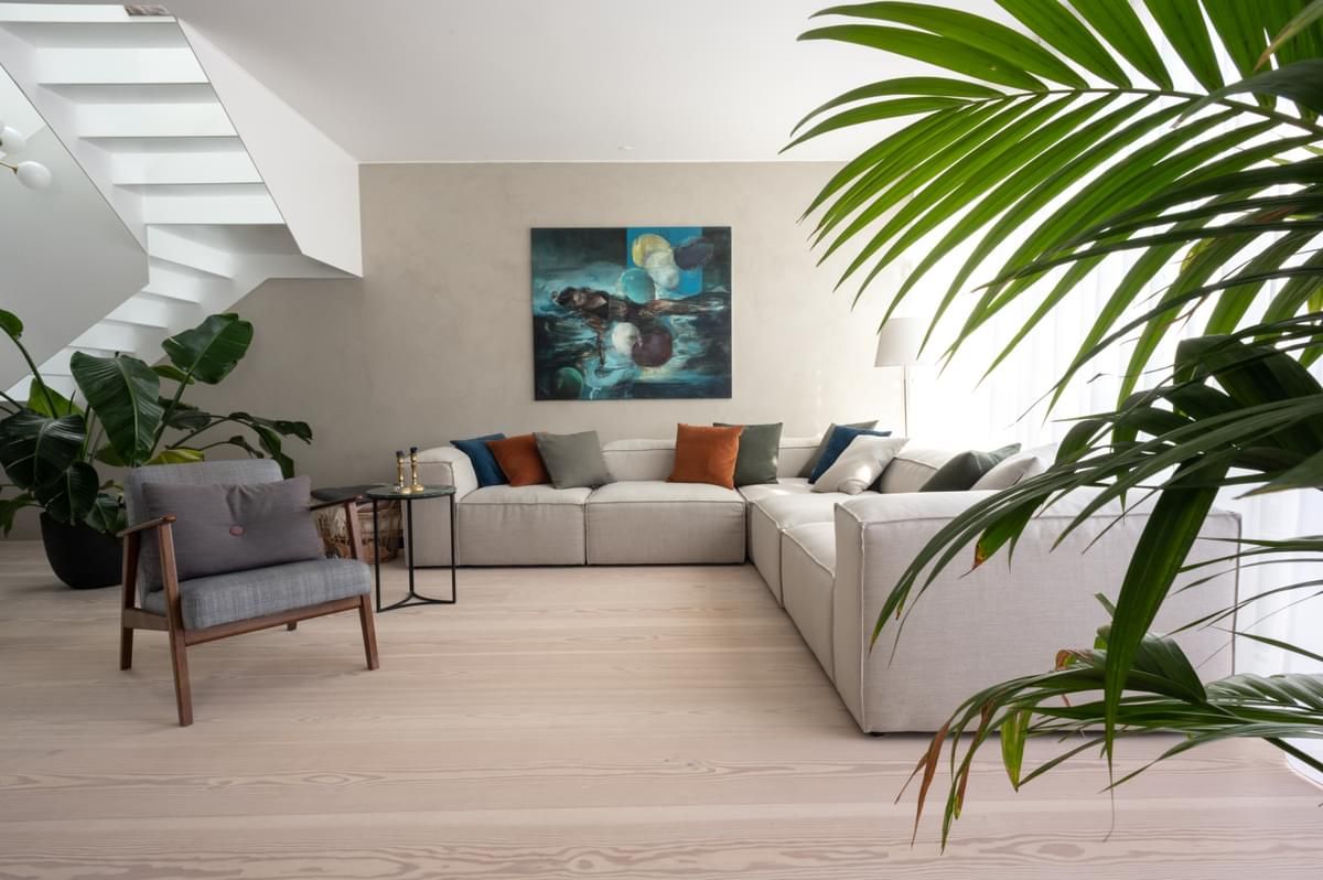 En stue med sofa , stol , bord og trapp.