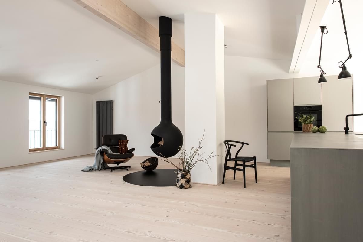 En stue med peis hengende i taket og en stol.