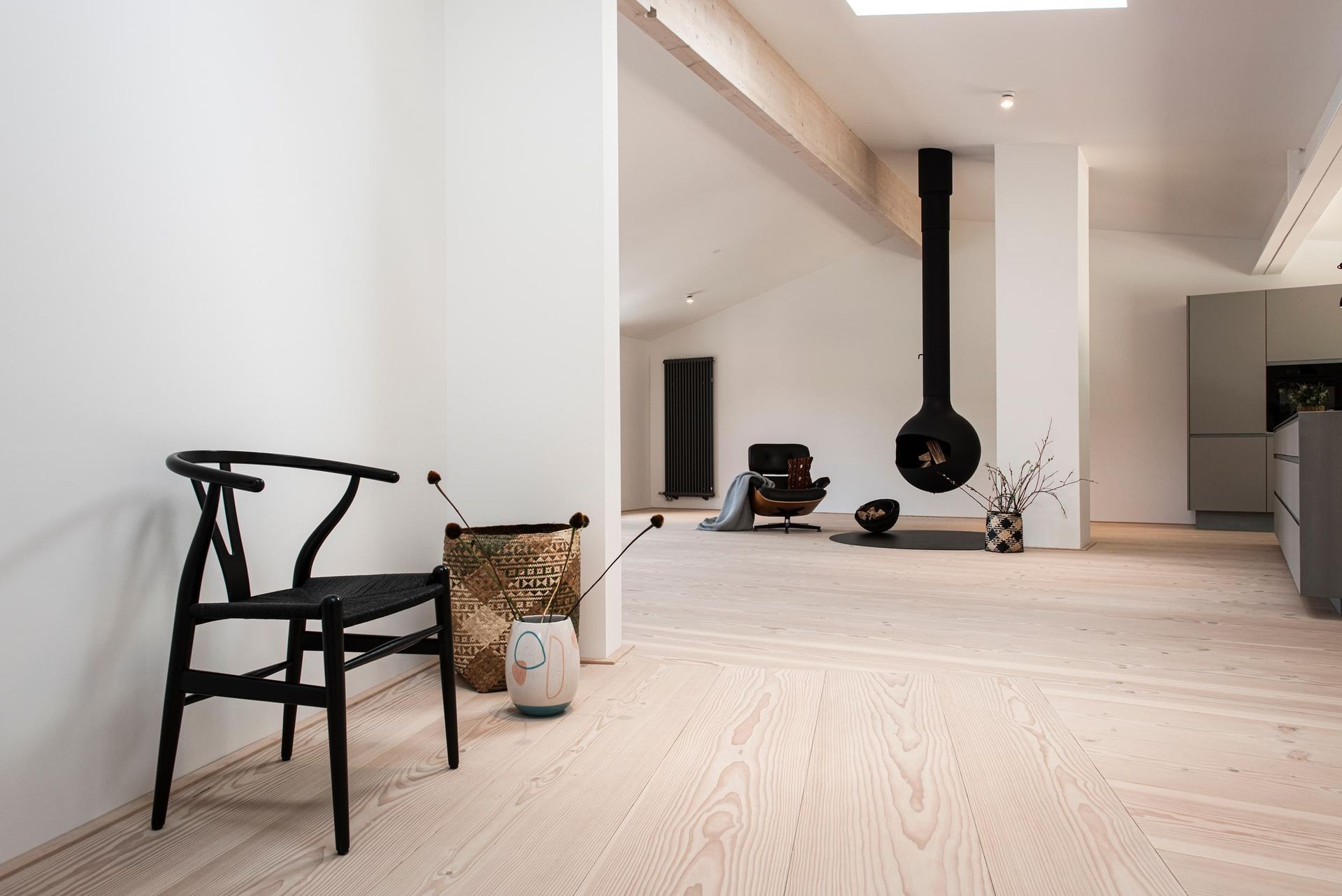 En svart stol sitter i en stue ved siden av en peis.