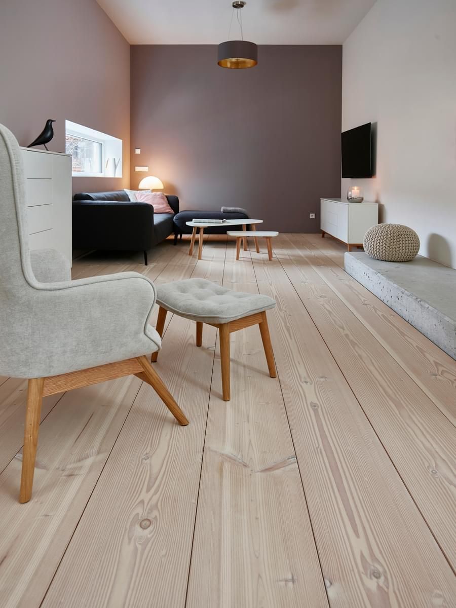 En stue med stol og ottoman på gulvet