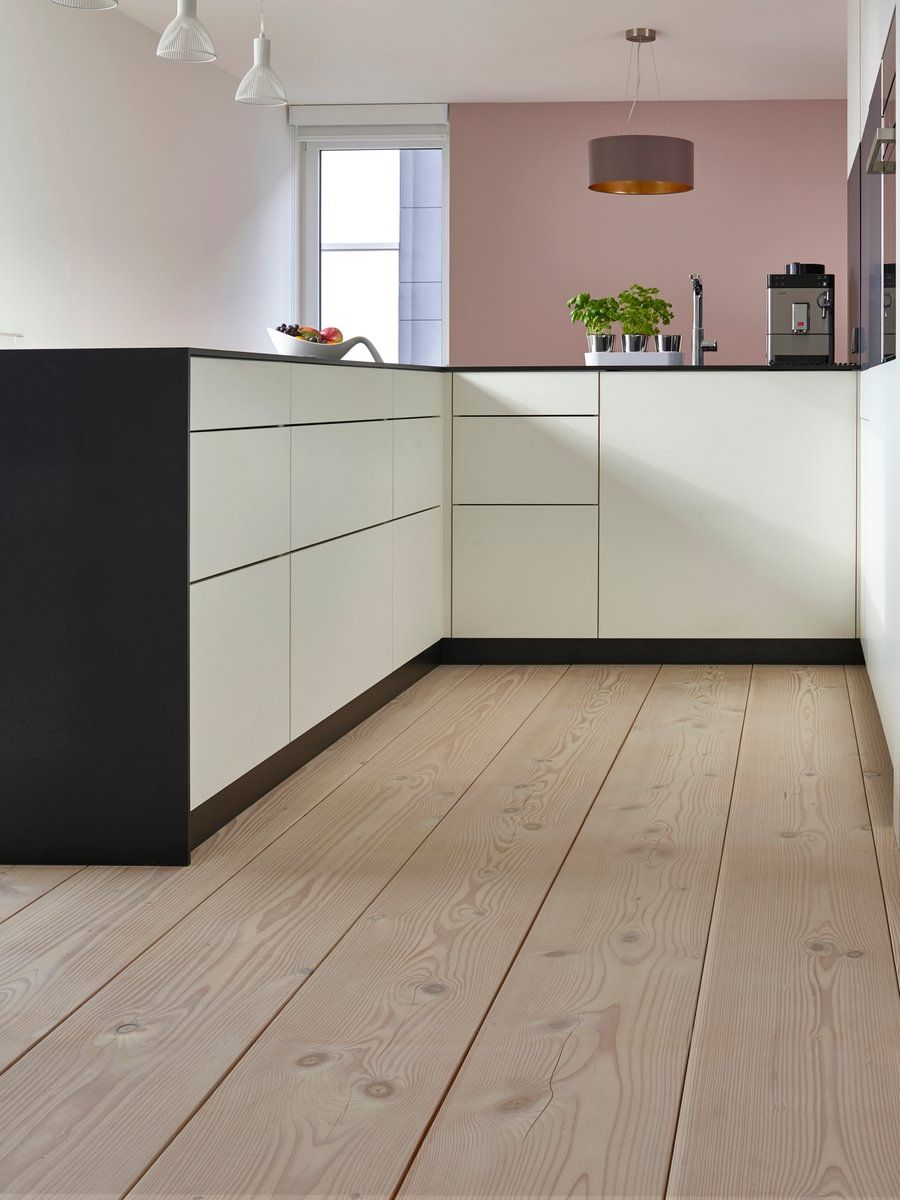 Et kjøkken med tregulv og hvite skap