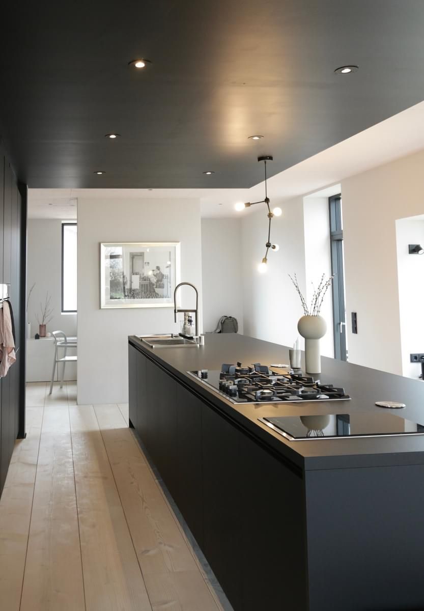 Et kjøkken med komfyrtopp og vask