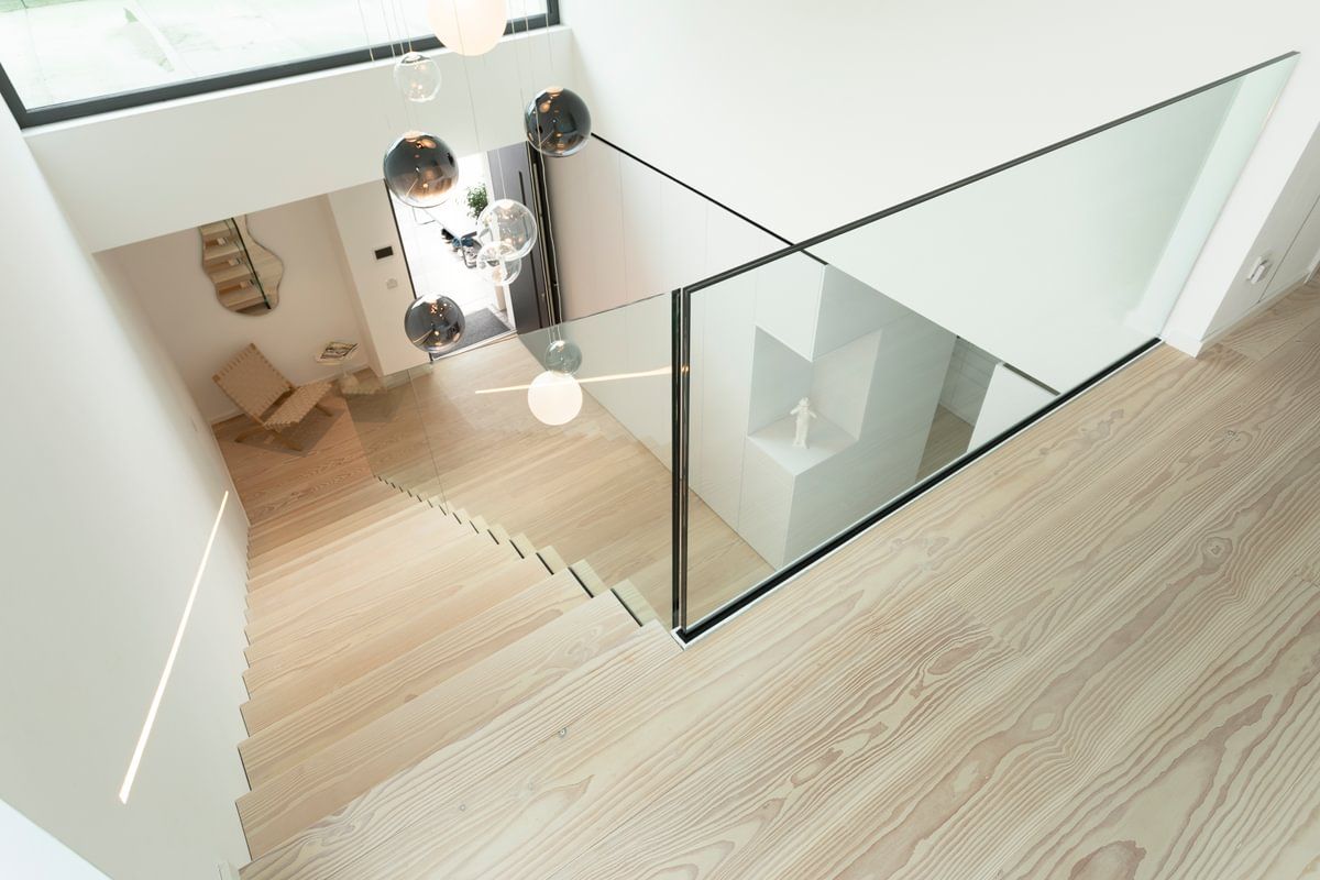 En trapp med glassrekkverk og tregulv