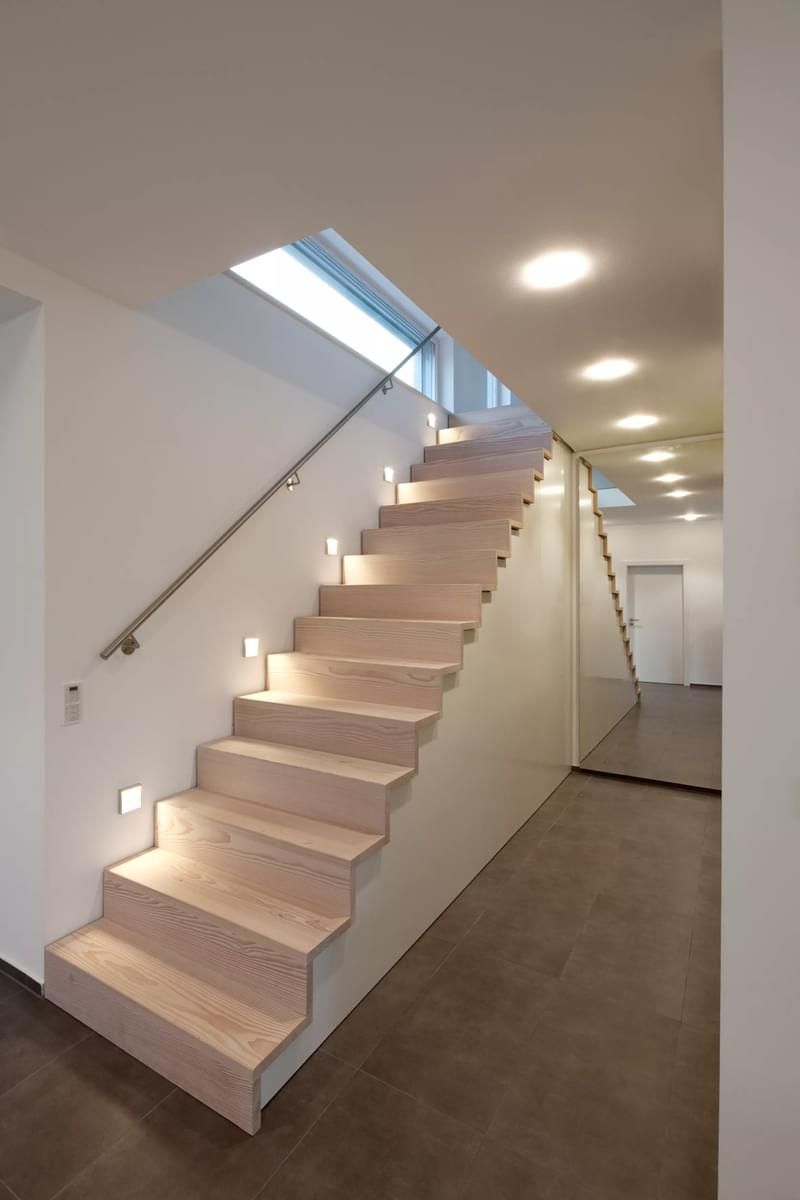 En tretrapp i en gang med lys på trappetrinnene