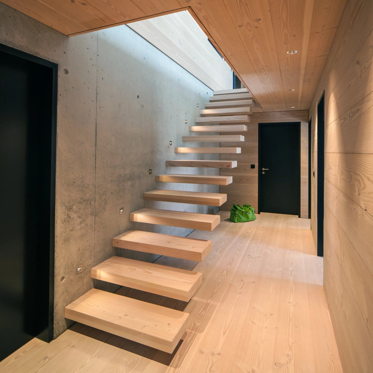 En tretrapp i en gang med svart dør