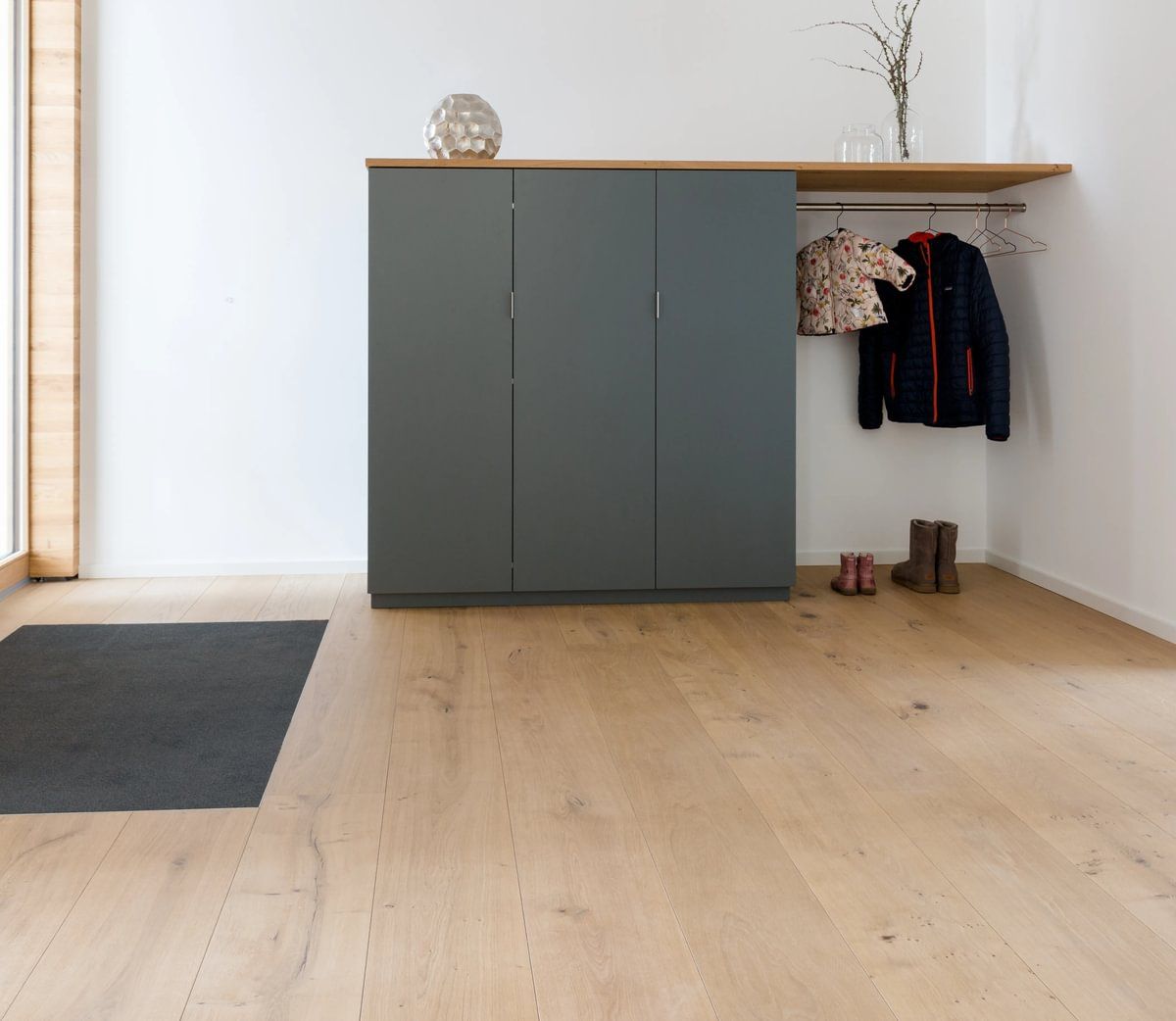 Et rom med tregulv og grått skap