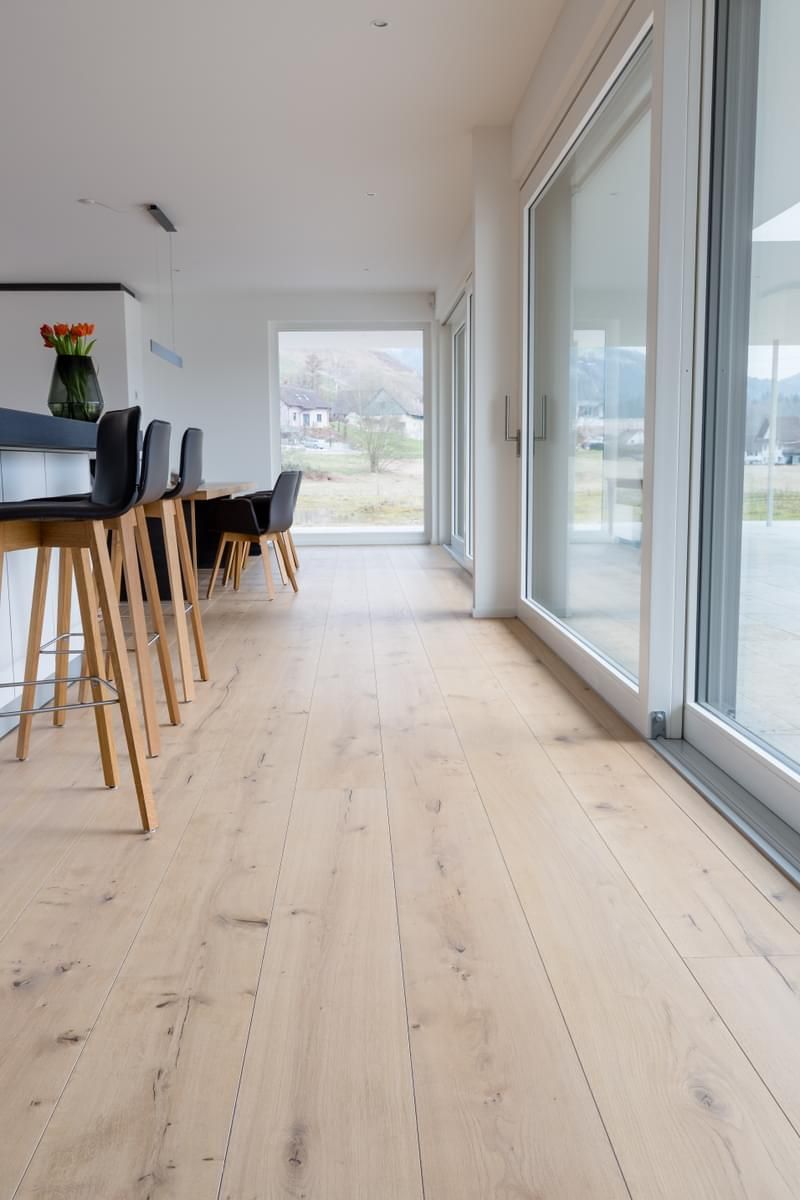 En spisestue med tregulv og skyvedører i glass.