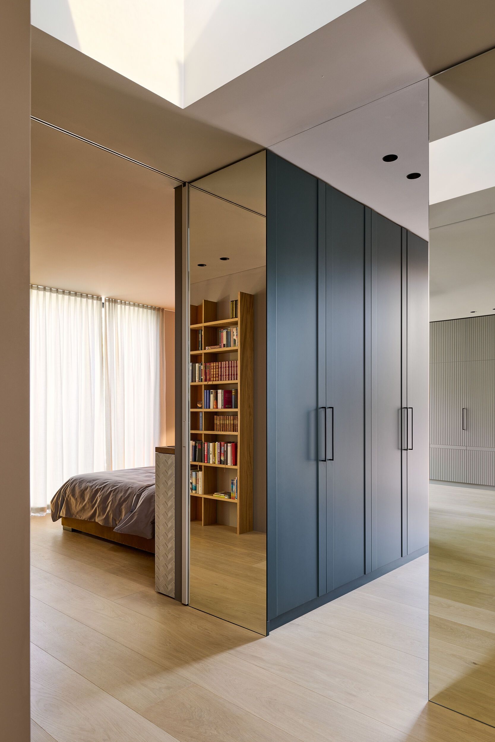 Et soverom med speilvegg mellom soverom og stue.