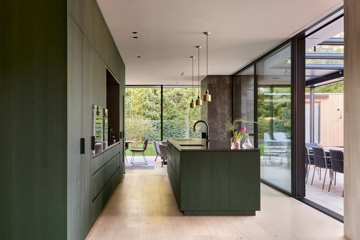 Et kjøkken med grønne skap og en stor øy.