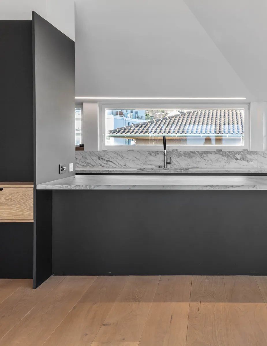 Et kjøkken med benkeplate i marmor og et vindu.