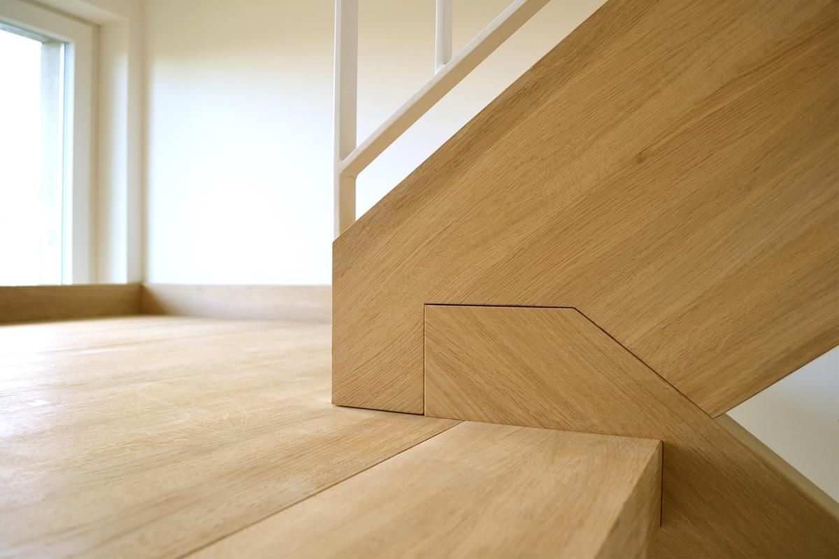 Et nærbilde av en tretrapp i et tomt rom.