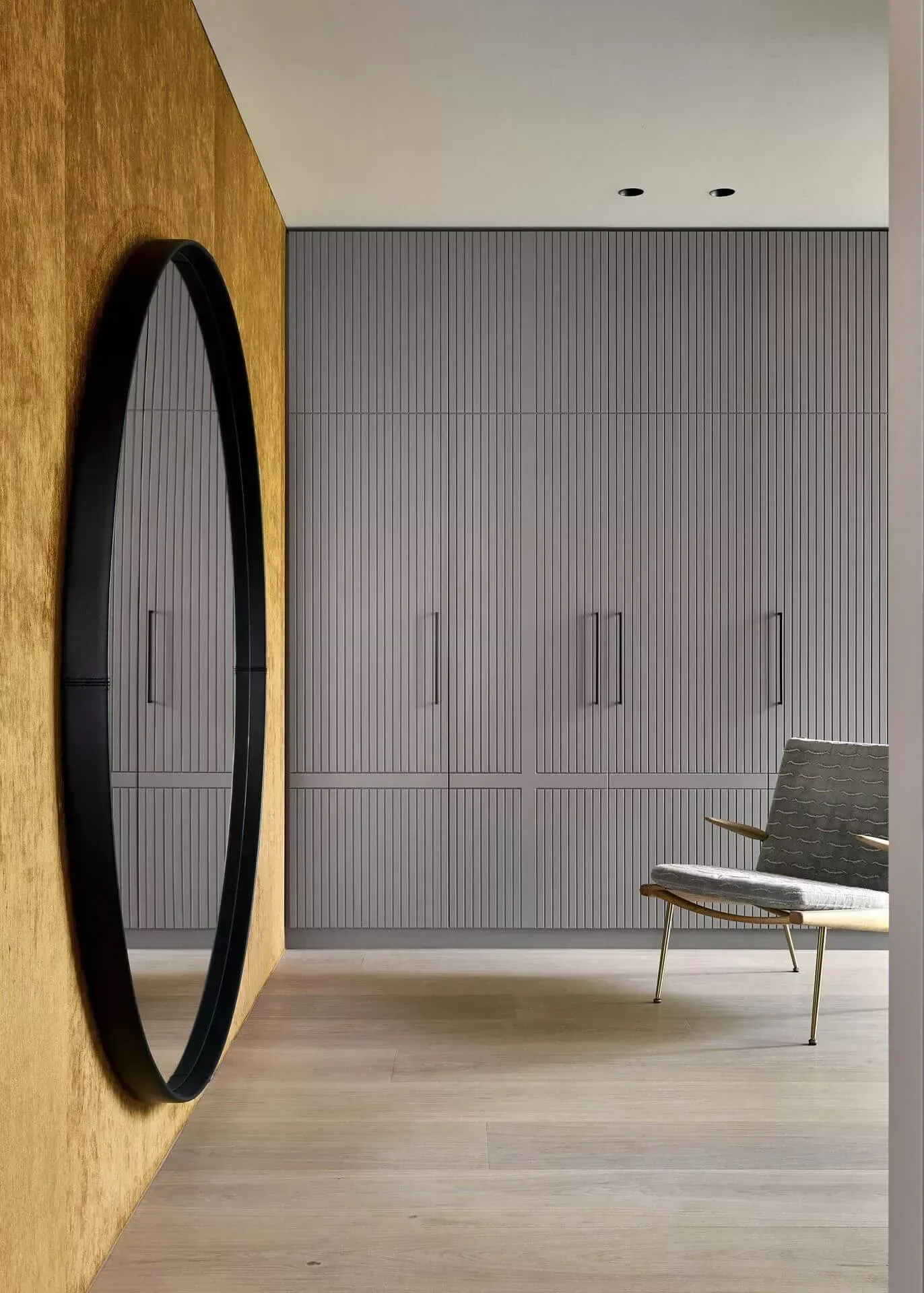 Et rom med en stol og et speil på veggen.